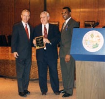 A picture of State Attorney Wolfinger receiving the 1996 Governor's Community Investment Award from Lt. Governor Buddy McKay and Department of Juvenile Justice Secretary Calvin Ross.