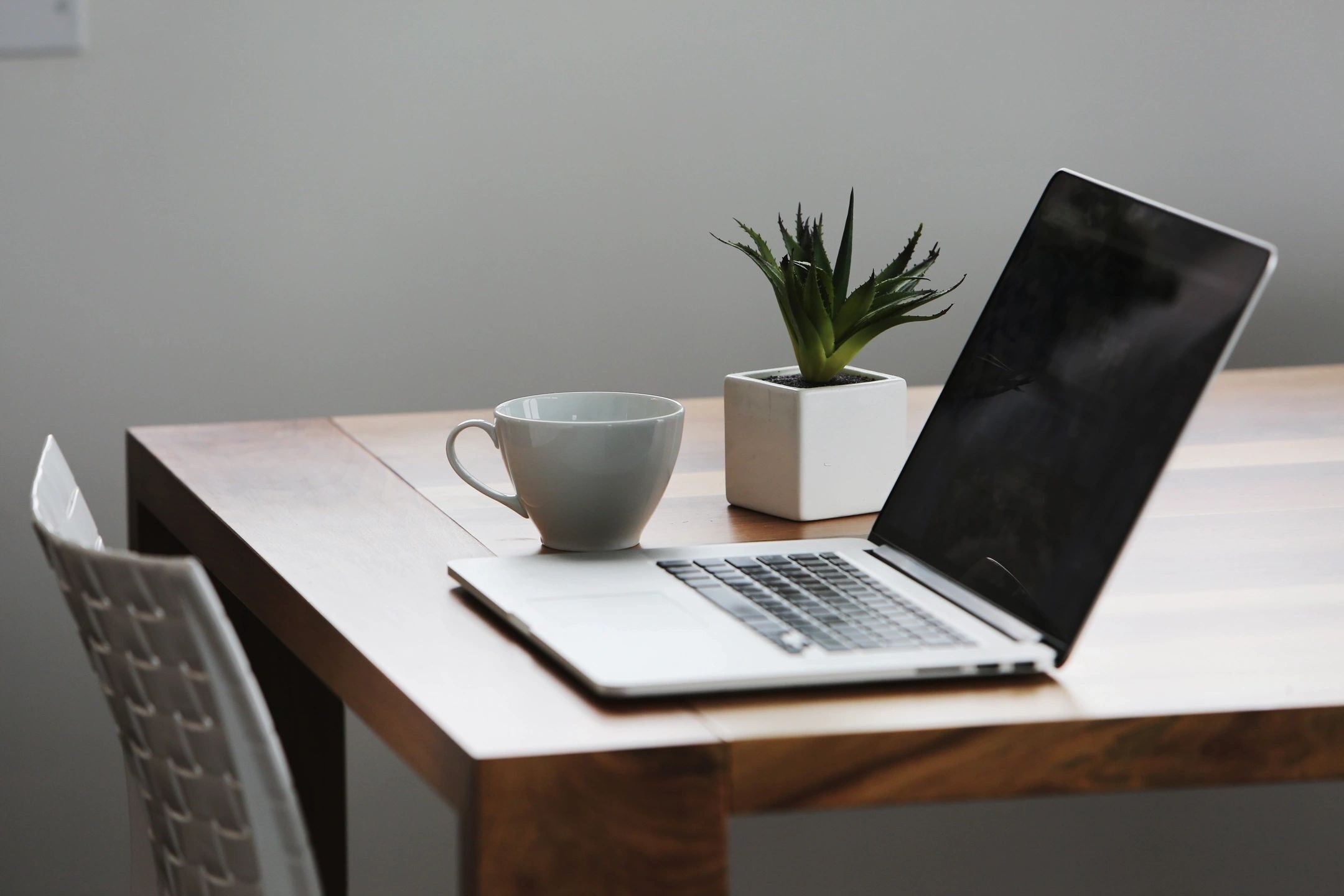 Link to Media contact; Photo of laptop, plant, and coffee cup on wooden table