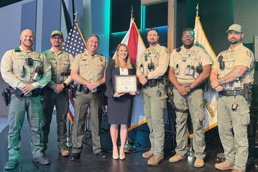 Assistant State Attorney Christina Vicari, center of photo, isjoined at a June 16 award ceremony by the team of FWC officers she works with to prepare cases for prosecution in Seminole County.